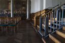 A dark-finished Liftup FlexStep integrated into the stair of a historic public building, seated hall visible beyond