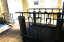 Close view of a dark Liftup FlexStep platform and balustrade against stone, showing the perforated platform deck and side frame
