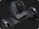 View of the WHILL Model C Lite carbon fibre footplate between the two front wheels, with the rear drive unit behind it.