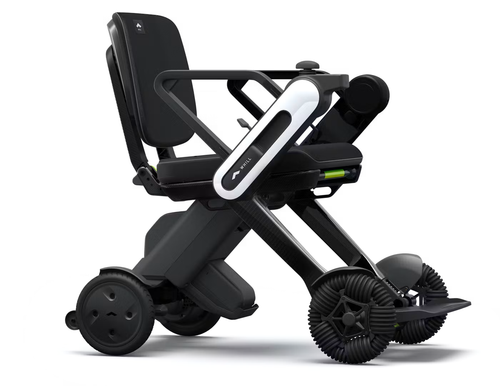 WHILL Model C Lite folding carbon electric wheelchair, side view, showing the carbon fibre X-frame, black seat and backrest, white WHILL arm-mounted controller, and front omni-directional wheels.